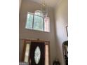Grand foyer with a tall window, ornate light fixture, and decorative front door at 6570 Laurens Way, Stone Mountain, GA 30087