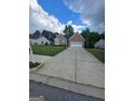Traditional-style home with a well-manicured lawn and an extended concrete driveway at 1925 Cedar Walk Ln, Conley, GA 30288