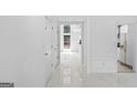 Bright hallway with white walls, porcelain tile floors and access to a kitchen at 984 Wenham Ln, Lawrenceville, GA 30044