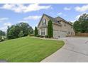 Side view of a charming two-story house with a long driveway and well-kept lawn at 108 Donovan Ave, Locust Grove, GA 30248