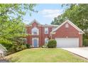 Charming two-story brick home with a manicured front lawn and an attached two-car garage at 2600 Neighborhood Walk, Villa Rica, GA 30180