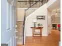 Inviting foyer features hardwood floors, a staircase with iron railings, and views into the home's open layout at 2600 Neighborhood Walk, Villa Rica, GA 30180