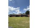 Quaint brick house with a well-maintained lawn, complemented by dark shutters and neatly trimmed shrubbery at 410 Clubland Se Cir, Conyers, GA 30094