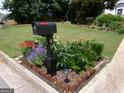Well-maintained front yard featuring a mailbox adorned with colorful flowers and lush greenery at 49 Brinkley Ct, Dallas, GA 30157