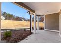 Covered patio with white pillars, overlooking a spacious backyard with lush, natural surroundings at 296 Deer Creek Run # 11, Moreland, GA 30259