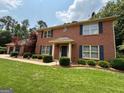 Classic brick home with well-maintained landscaping, blue shutters, and a welcoming front entrance at 404 Windsor Way, Peachtree City, GA 30269