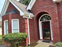 Close-up view of home's exterior with a red brick facade and manicured landscaping at 3955 Sweetwater Pkwy, Ellenwood, GA 30294