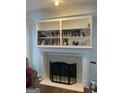 Cozy fireplace featuring white mantle and shelving with decorative tile surround and hearth at 3955 Sweetwater Pkwy, Ellenwood, GA 30294