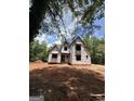 New home under construction featuring a charming gable roof with a spacious yard, surrounded by lush greenery at 385 Snead Rd, Fayetteville, GA 30215