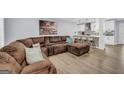 Comfortable living room showcasing a large sectional sofa and an open layout with a view into the kitchen at 557 Spring Creek Ne Way, Marietta, GA 30068