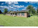 Beautiful brick home featuring a covered front porch and lush green lawn at 12621 Highway 142, Oxford, GA 30054