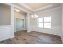 Bright dining area with hardwood floors, decorative wainscoting, and elegant lighting fixture at 267 Eason St, Bowdon, GA 30108