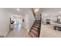 Bright foyer with staircase leading to the second floor and views of the kitchen at 263 Eason St, Bowdon, GA 30108