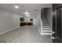 Open-concept living area with gray floors, leading to a kitchen and staircase at 2137 Chadwick Sw Rd, Atlanta, GA 30331