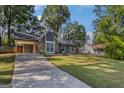 Home featuring stone accents, a covered carport, a well-manicured lawn, and long concrete driveway at 113 Caldwell Dr, Hampton, GA 30228