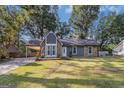 Charming home featuring stone accents, a covered carport, a well-manicured lawn, and tasteful landscaping at 113 Caldwell Dr, Hampton, GA 30228