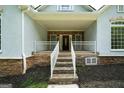 Inviting front porch with stone steps, white railings, and a cozy entrance to the home at 1460 Bakers Bridge Rd, Douglasville, GA 30134