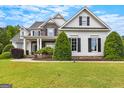Charming home with stone accents, dark shutters, perfectly trimmed landscaping, and vibrant green lawn at 55 Jolie Ln, Sharpsburg, GA 30277