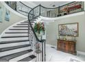 Elegant foyer with a curved staircase, wrought iron railings, and marble flooring with decor at 413 Canterbury Way, Jonesboro, GA 30236