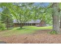 Attractive brick home with shutters, nestled among the trees, offering curb appeal and a serene setting at 190 Willow Lake Ln, Sharpsburg, GA 30277