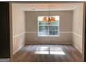 Well-lit dining room featuring chair rail molding, chandelier and a large window at 149 Titan Rd, Stockbridge, GA 30281
