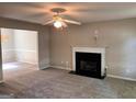 Spacious living room with a fireplace, carpet flooring and ceiling fan for added comfort at 149 Titan Rd, Stockbridge, GA 30281
