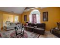 Vaulted ceiling living room with yellow walls, fireplace, and lots of seating space, with large windows for plenty of light at 7101 Brecken Pl, Lithonia, GA 30058