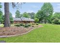 Classic brick home with a sprawling lawn, mature landscaping, and a welcoming curb appeal at 602 Pine Knoll Court, Mcdonough, GA 30252