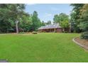 Spacious property with a well-maintained lawn, mature landscaping, and a charming brick facade at 602 Pine Knoll Court, Mcdonough, GA 30252