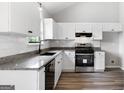 Bright kitchen boasts white cabinetry, granite countertops, and stainless steel appliances at 1432 Almand Creek Drive Sw, Conyers, GA 30094