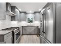 Modern kitchen featuring stainless steel appliances, gray cabinets and tile flooring at 7972 Woods Lane, Jonesboro, GA 30236