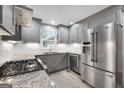 Modern kitchen with stainless steel appliances, granite countertops, and gray cabinetry at 7972 Woods Lane, Jonesboro, GA 30236