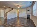 Open living room featuring a fireplace, ceiling fan, hardwood floors, and staircase to the second floor at 237 Cranapple Ln, Mcdonough, GA 30253