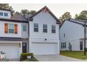 Charming two-story home showcasing white siding, a two-car garage, and a well-maintained lawn at 375 Auburn Valley Way, Auburn, GA 30011