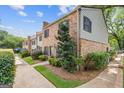 Lovely exterior view of townhome with brick facade, lush landscaping, and sidewalk at 242 Adair St, Decatur, GA 30030