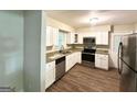 Updated kitchen with stainless steel appliances, granite countertops, and white cabinetry at 570 Kenridge Cir, Stone Mountain, GA 30083
