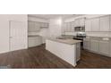 Modern kitchen features gray cabinets, granite countertops, stainless steel appliances and a center island at 11884 Aukerman Way, Hampton, GA 30228