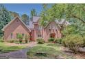 Beautiful brick home featuring a well-manicured lawn, lush landscaping, and a charming walkway to the front entrance at 305 Sherwood Rd, Fayetteville, GA 30215