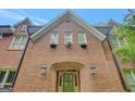 Close-up of the brick facade with an arched entryway, complemented by decorative window boxes and stylish exterior lighting at 305 Sherwood Rd, Fayetteville, GA 30215