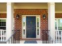 Close-up of a stylish front door with sidelights, a welcome mat, and decorative lanterns at 1120 Bagwell Dr, Kennesaw, GA 30152