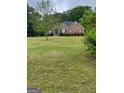 A beautiful one-story brick house with a green lawn and flowering bushes at 2142 E Atlanta Rd, Stockbridge, GA 30281