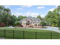 Elegant brick home with a manicured lawn, mature landscaping, and gated entrance at 1385 Gordon Rd, Moreland, GA 30259