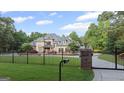 Gated property with a large, beautiful home featuring lush landscaping and a stately presence at 1385 Gordon Rd, Moreland, GA 30259