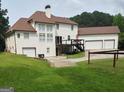 Spacious backyard featuring a well-kept lawn, deck, and three-car garage at 130 Victoria Pl, Fayetteville, GA 30214