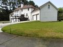 Backyard view of a spacious home with a lawn, deck, and three-car garage at 130 Victoria Pl, Fayetteville, GA 30214