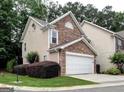 Side exterior view of a well-maintained townhome with stone accents and lush landscaping at 2804 Dominion Nw Ln # Bldg 2, Kennesaw, GA 30144