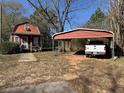 The home has a red exterior, a small porch, and a covered carport with a white truck at 10142 Washington Street, Covington, GA 30014