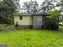Exterior view of a home with a wooden deck, surrounded by a well-manicured lawn at 22 Shell Rd, Carrollton, GA 30116