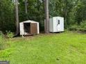 Two backyard sheds offer storage solutions in a serene wooded environment at 22 Shell Rd, Carrollton, GA 30116