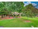 Well maintained house showcasing manicured lawn, trees and landscaping at 55 Ashton Pl, Covington, GA 30016